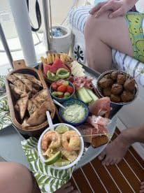 A beautifully arranged spread of snacks and seafood on a boat, perfect for enjoying a relaxing day on the water with friends.