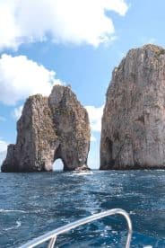 A stunning view of iconic rock formations with a boat navigating through the waters, showcasing the breathtaking coastline and natural beauty of the destination.
