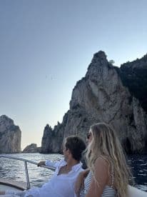 A couple enjoys a scenic boat ride past stunning cliffs, capturing the essence of a romantic getaway on the water.