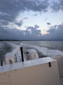 A sleek speedboat cuts through the water, leaving a wake behind as it navigates under a dramatic sky, perfect for adventure seekers on the water.