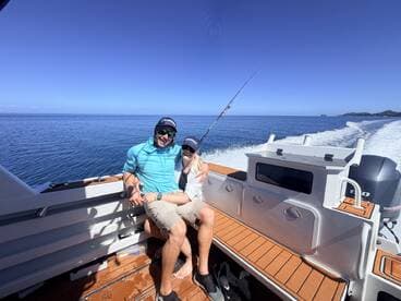 A couple enjoys a fishing adventure on a boat, surrounded by calm ocean waters — perfect for creating unforgettable memories on the water.