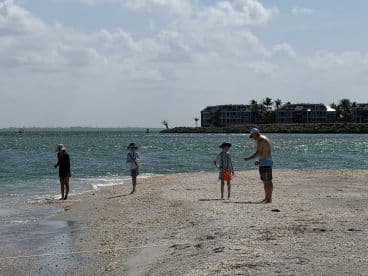 A family enjoys a day at the beach, exploring the shoreline and creating memories during a sandbar stop — perfect for family outings and fun in the sun.