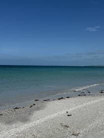 A serene beach scene featuring clear turquoise waters and a sandy shore, perfect for relaxation and enjoying nature.