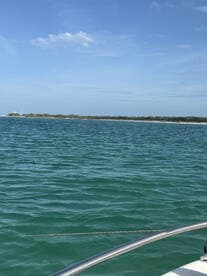A serene view of turquoise waters with a distant shoreline, showcasing the beauty of a day on the water.