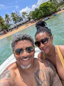 A joyful couple poses for a selfie on a boat, enjoying a sunny day at the beach — perfect for romantic getaways and memorable adventures on the water.
