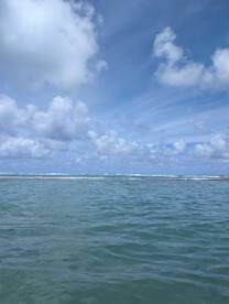 A scenic view of the ocean with clouds overhead, but the image lacks clarity and focus.