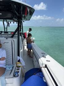 A child and an adult enjoy a fishing trip on a boat, creating memorable family moments on the water.