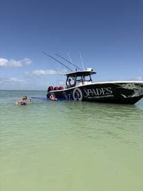 A family enjoys a fun day in the water near their boat, creating lasting memories with swimming and relaxation under the sun.