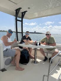 Three friends enjoy a relaxing moment on the boat's interior, sharing drinks and snacks — perfect for socializing on the water.
