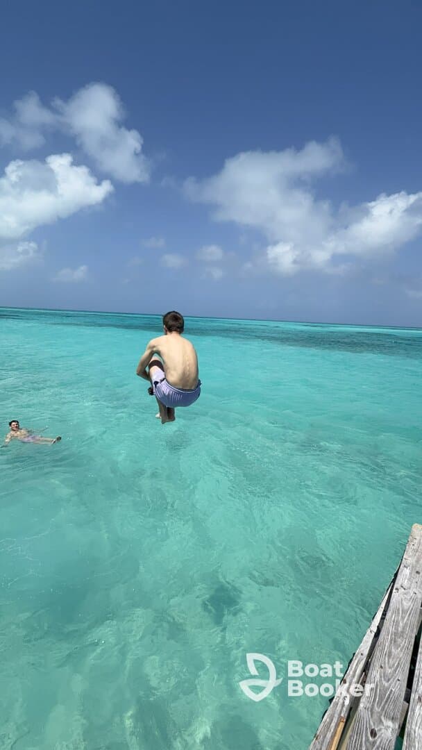 A young boy leaps into the crystal-clear turquoise waters, capturing the essence of summer fun and adventure in a tropical paradise.