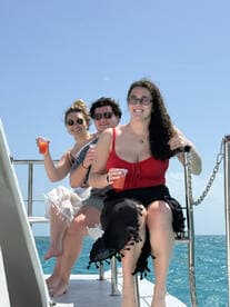 A cheerful group enjoys cocktails on the deck of a boat, capturing the essence of a fun day out on the water.
