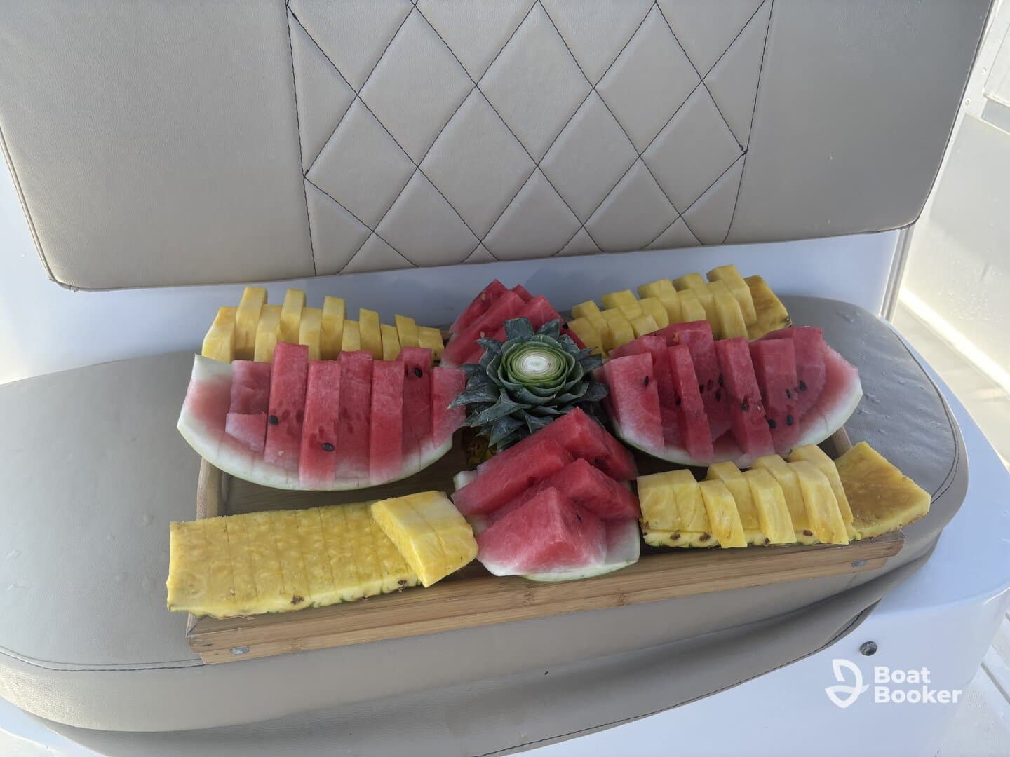 A beautifully arranged platter of fresh watermelon and pineapple, perfect for enjoying on a boat trip. Ideal for refreshing snacks while cruising on the water.
