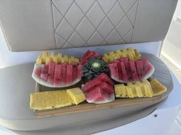 A beautifully arranged platter of fresh watermelon and pineapple, perfect for enjoying on a boat trip. Ideal for refreshing snacks while cruising on the water.