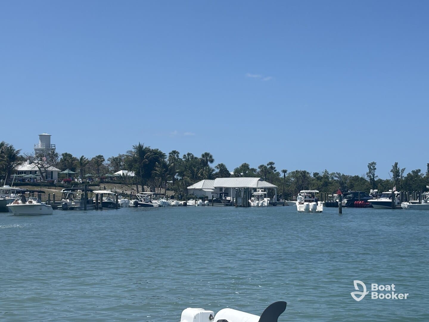 A scenic view of a marina filled with various boats docked along the waterfront, showcasing a vibrant boating community.