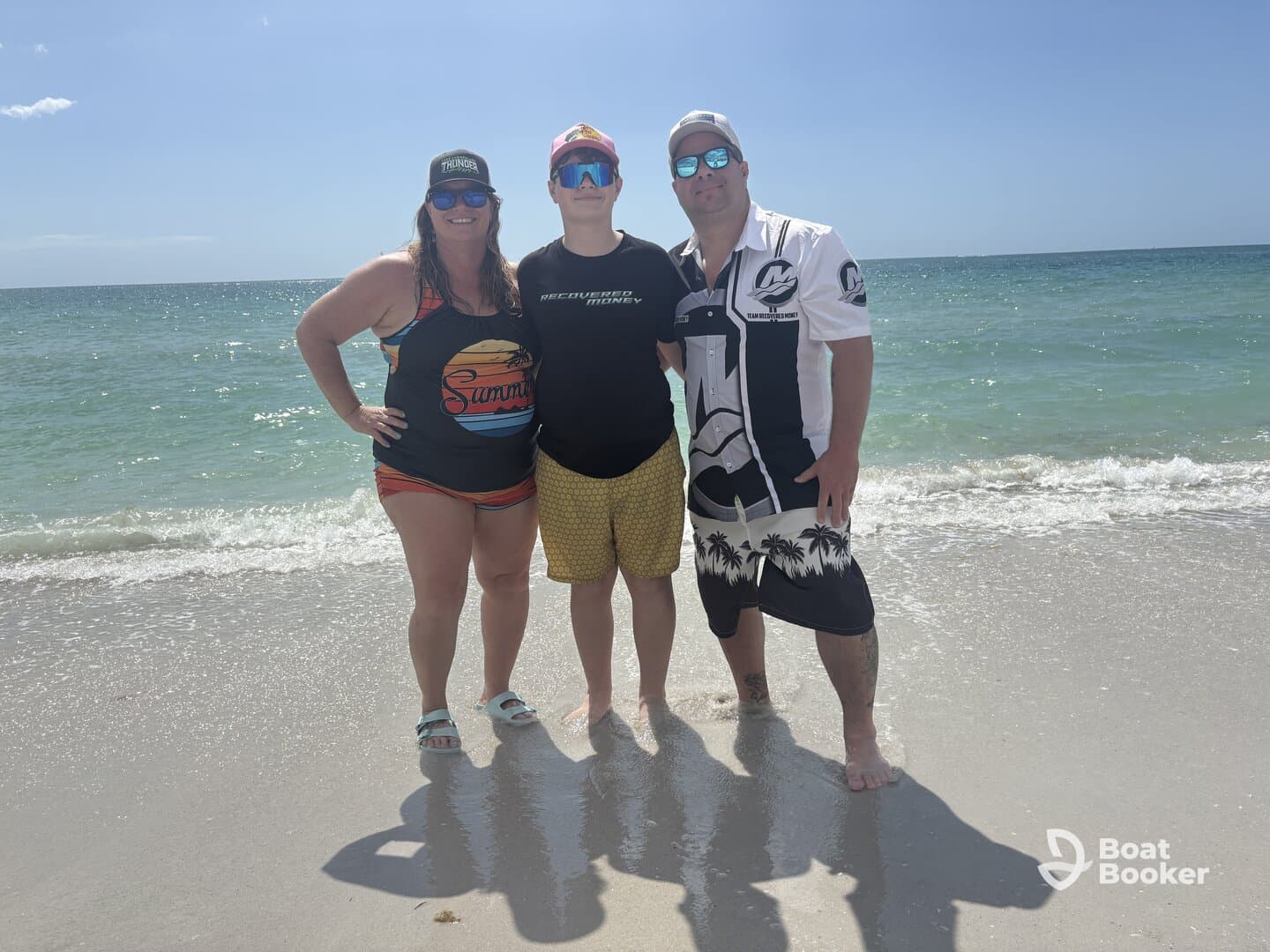 A cheerful group poses on the beach, enjoying a sunny day by the water — perfect for family outings and beach adventures.