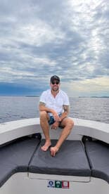 A man enjoys a relaxing moment on the boat, surrounded by calm ocean waters — perfect for a day of leisure on the water.