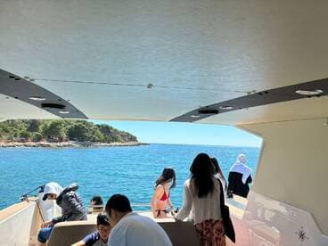 A lively group enjoys a day on the water, with scenic views of the coastline and fun activities aboard the boat.