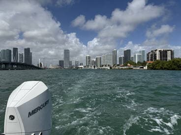 A scenic view of Miami's skyline from the water, showcasing the vibrant cityscape and the excitement of boating in the area.