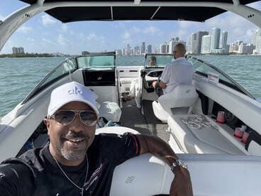 A joyful selfie taken aboard a boat with a stunning city skyline in the background, capturing the essence of a fun day on the water.
