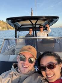 A cheerful group of friends enjoys a boat ride at sunset, capturing the perfect moment on the water — ideal for memorable outings and adventures.