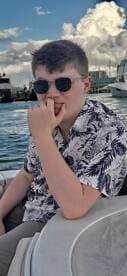 A young boy enjoys a moment on a boat, showcasing a relaxed atmosphere on the water. Perfect for family outings or summer adventures.