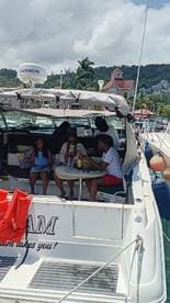A group enjoys a relaxing moment on a boat, sharing drinks and laughter, perfect for a fun day on the water.