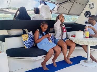 A cozy interior view of a boat's lounge area featuring guests relaxing and enjoying drinks, perfect for social gatherings on the water.