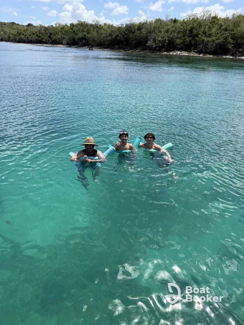 A group of friends enjoys a refreshing swim in crystal-clear waters, perfect for a day of fun and relaxation in the sun.