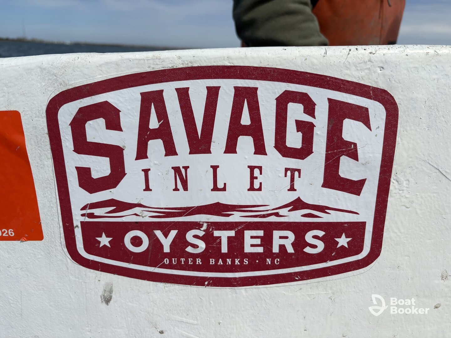 Close-up of the Savage Inlet Oysters logo on a boat, showcasing the brand from Outer Banks, NC.