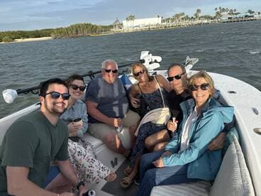 A cheerful group enjoys drinks aboard a boat, capturing the essence of a fun day on the water with friends.