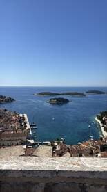 A stunning aerial view of a picturesque harbor with islands in the distance, showcasing the beauty of coastal landscapes and perfect for travel inspiration.