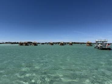 A vibrant scene of pontoon boats anchored near sandy islands, showcasing a perfect day for relaxation and fun in the sun.