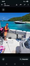 A young boy proudly holds a fishing rod on a boat, showcasing his catch against a stunning turquoise ocean backdrop — a perfect family fishing adventure.
