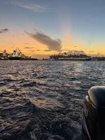A stunning sunset view over the harbor, featuring a large cruise ship illuminated against the evening sky — perfect for capturing the beauty of maritime adventures.