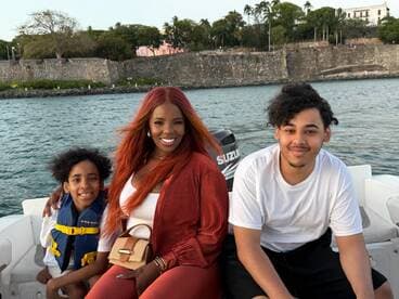 A joyful family enjoys a boat ride, capturing a moment of togetherness with smiles and scenic views in the background.