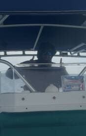 A confident captain gives a thumbs up from the helm of the boat, showcasing the interior console and navigation equipment.