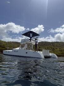 Two individuals aboard a Manta 38 catamaran prepare for a fishing adventure in clear waters, showcasing the excitement of on-water activities.