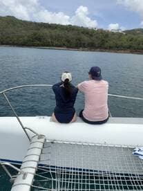 A couple enjoys the serene views from the bow of a boat, perfect for romantic getaways or scenic cruises.