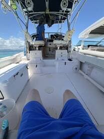 An interior view of a boat's helm area, featuring the console and seating, with a person standing at the controls — perfect for navigating the open waters.