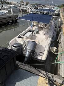 A center console boat docked at the marina, showcasing its sleek design and ready for a day on the water.