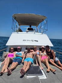 A lively group enjoys sunbathing on the deck of the 'Mr Pelicano' boat, perfect for fun-filled days on the water with friends.