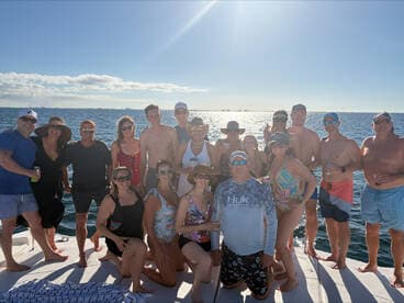 A lively group of friends gathers on the deck of a boat, enjoying a sunny day on the water — perfect for celebrations and memorable outings.