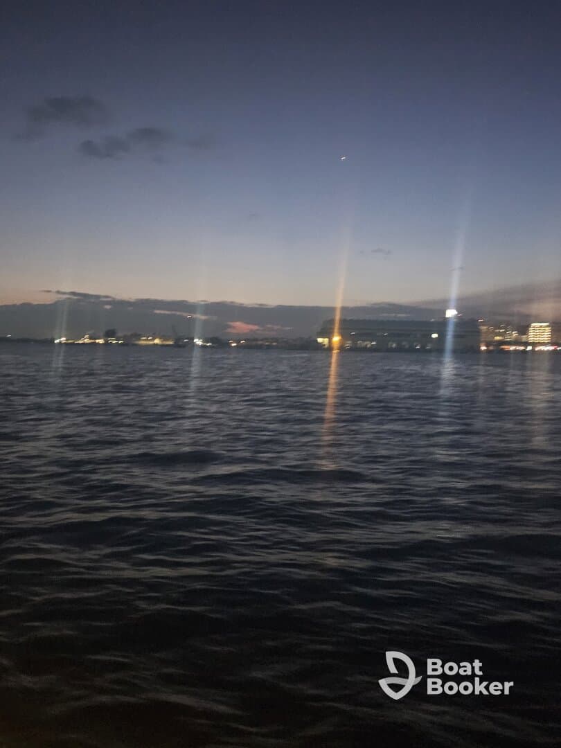 A nighttime view of the water with distant lights, creating an unclear and ambiguous scene.