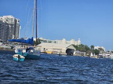 A picturesque sailboat navigates the waters near a marina, showcasing the vibrant atmosphere of boating life.