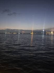 A nighttime view of the water with distant lights, creating an unclear and ambiguous scene.
