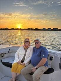 A couple enjoys a romantic sunset on a boat, creating the perfect backdrop for memorable moments on the water.