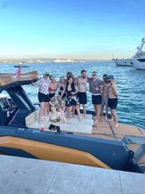 A lively group of friends celebrates on a stylish boat, enjoying a summer day by the water — perfect for parties and memorable outings.