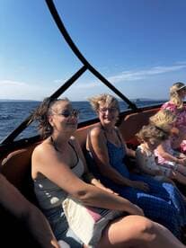 A joyful group of friends and family enjoy a boat ride on the ocean, capturing the essence of fun and togetherness on the water.