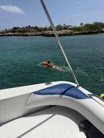 A child swims with a flotation device in clear turquoise waters, showcasing a fun day on the water — perfect for family adventures and beach outings.