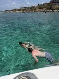 A couple enjoys snorkeling in crystal-clear waters, showcasing the beauty of marine life and the joy of underwater exploration.